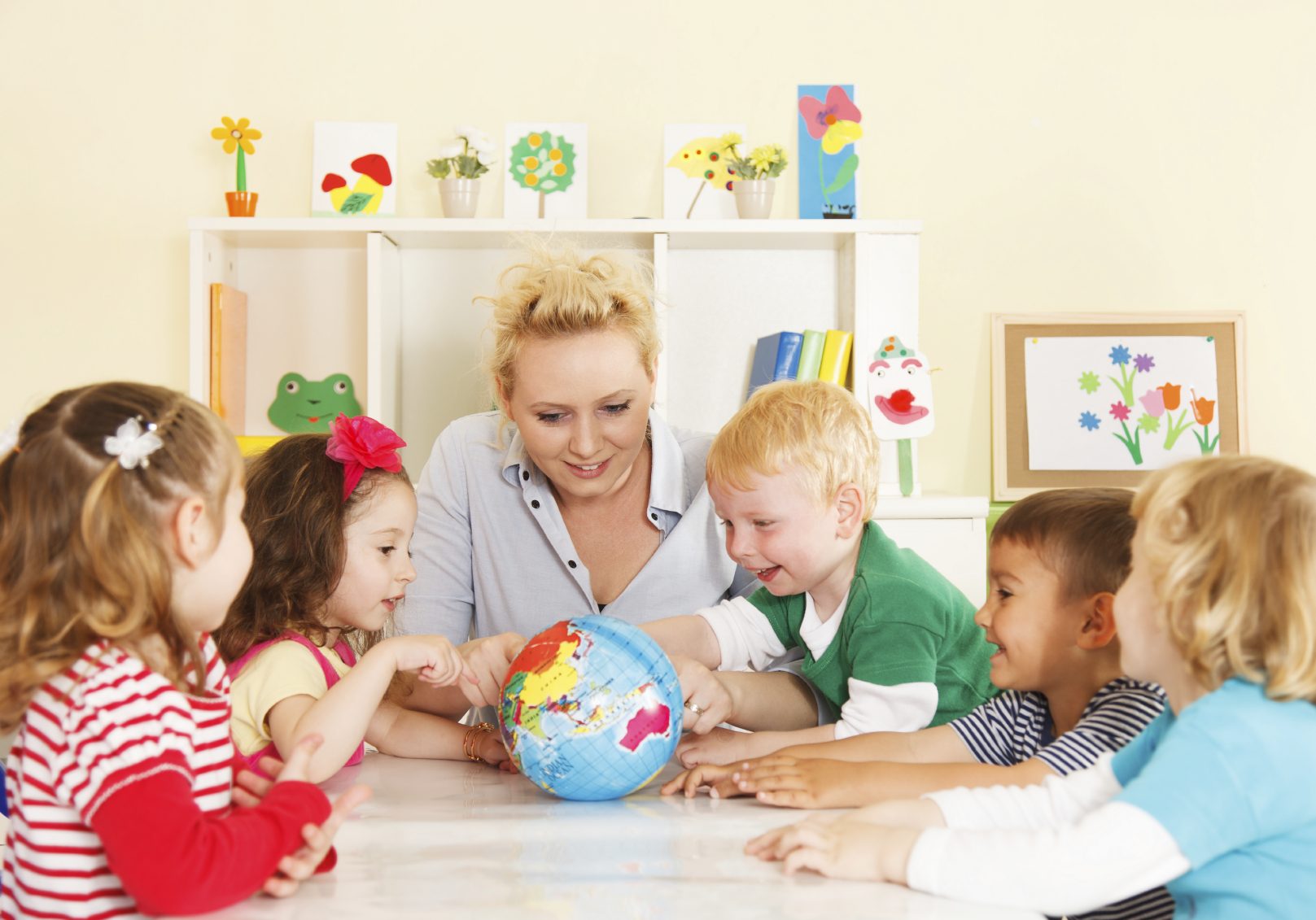 Multicultural childrens hands on a globe